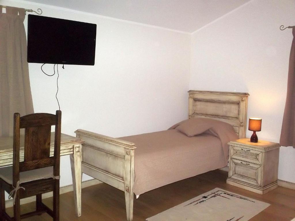 a bedroom with a bed and a desk and a television at Agroturism Stara Štala in Borut