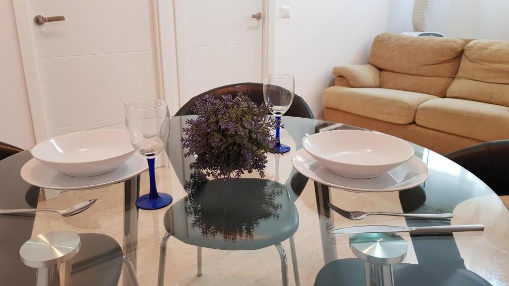 una mesa de cristal con 2 sillas y 2 copas de vino en Málaga Jerez, en Málaga