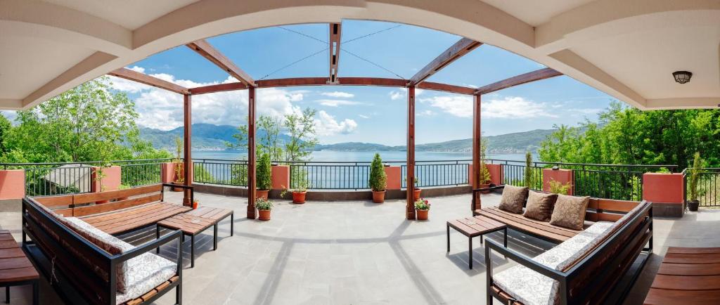 a balcony with benches and a view of the water at Odessa Mama in Bijela