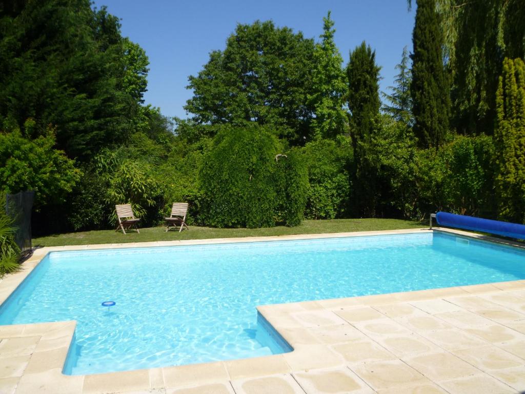 una gran piscina en un patio con árboles en Villa aux portes du Médoc, en Blanquefort