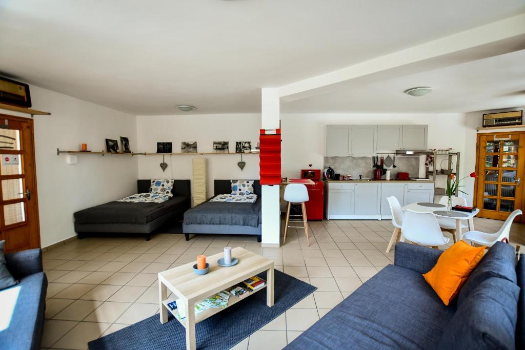 sala de estar con sofá azul y cocina en Borálom Stúdió Apartman Tokaj en Tokaj