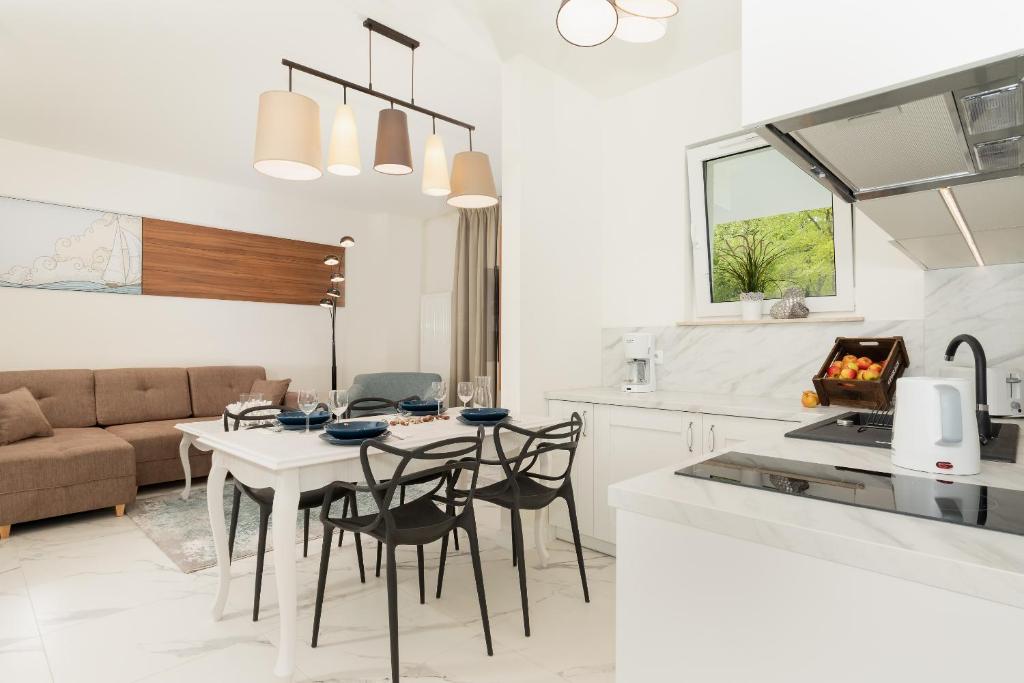 eine Küche und ein Wohnzimmer mit Tisch und Stühlen in der Unterkunft Aquamarina Onyx Marina Invest in Misdroy