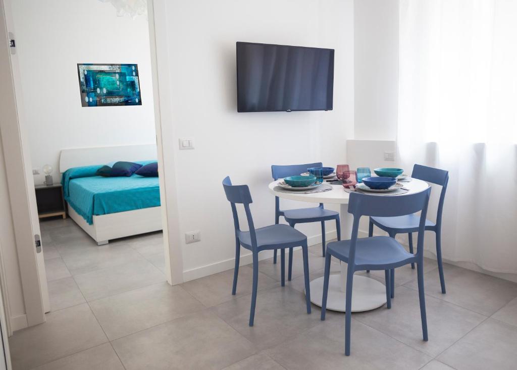 Milano Navigli Apartment - Zona Tortona في ميلانو: غرفة مع طاولة وكراسي وسرير