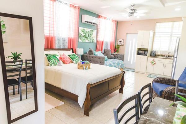 a bedroom with a bed and a living room at Eden's Garden in Isabela