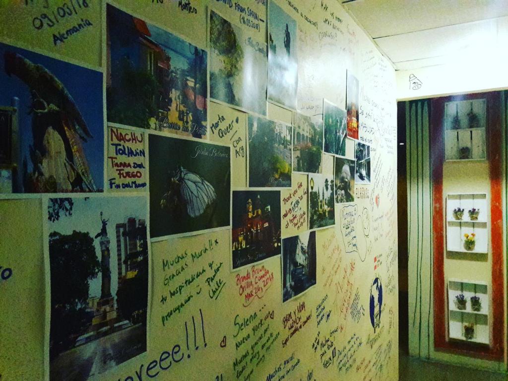 a wall covered with pictures and writing on it at Villa de María in Guayaquil