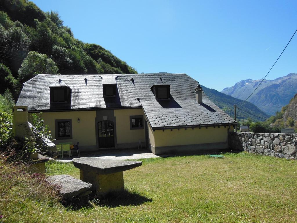 a house on a hill with a bench in front of it at gite tourmalet in Barèges