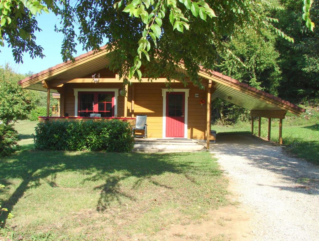 una pequeña casa con puerta roja y porche en Chalet Cahors - 4 pers., en Mauroux