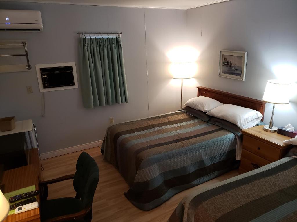 Postel nebo postele na pokoji v ubytování Pinecone Motel