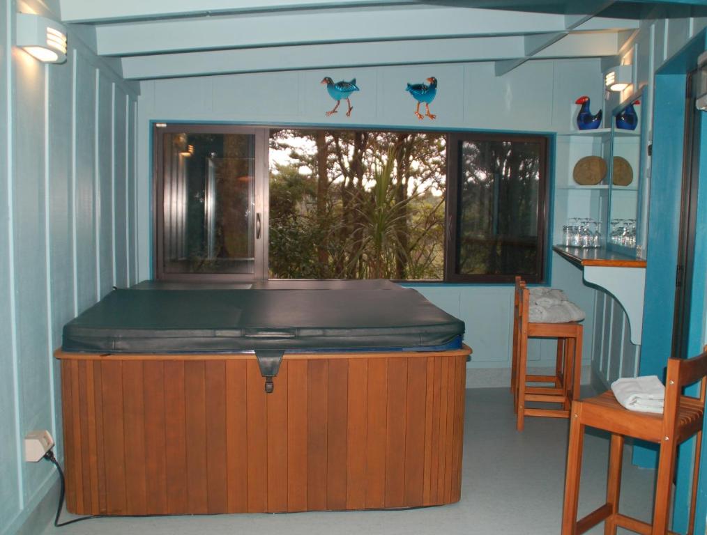 Habitación con bañera de hidromasaje en el centro de la habitación en Kohinui Glade Holiday Cottage, en Parua Bay