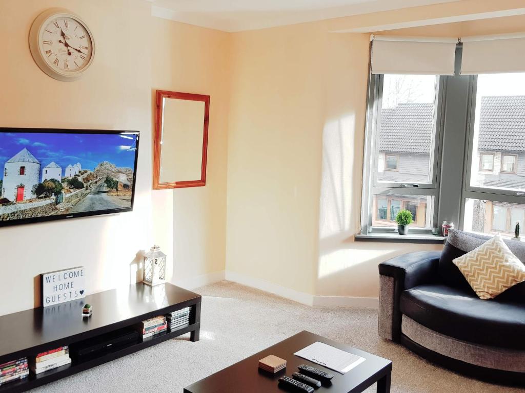 a living room with a couch and a tv at Three Bed Holiday Home in Glasgow in Glasgow