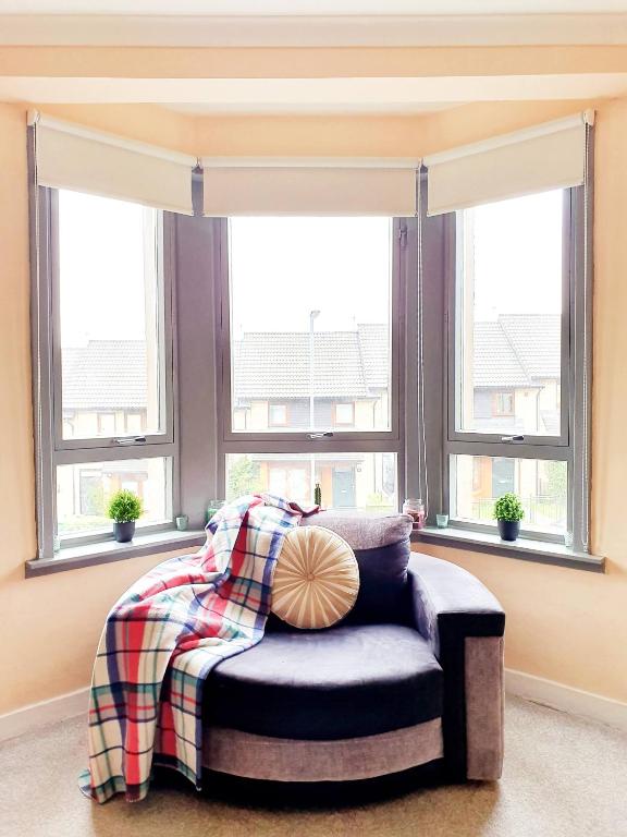 una camera da letto con un letto e due finestre di Three Bed Holiday Home in Glasgow a Glasgow
