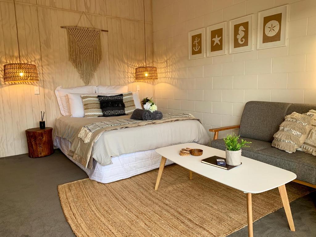 a bedroom with a bed and a couch and a table at Kaikōura Peaks eMotel in Kaikoura