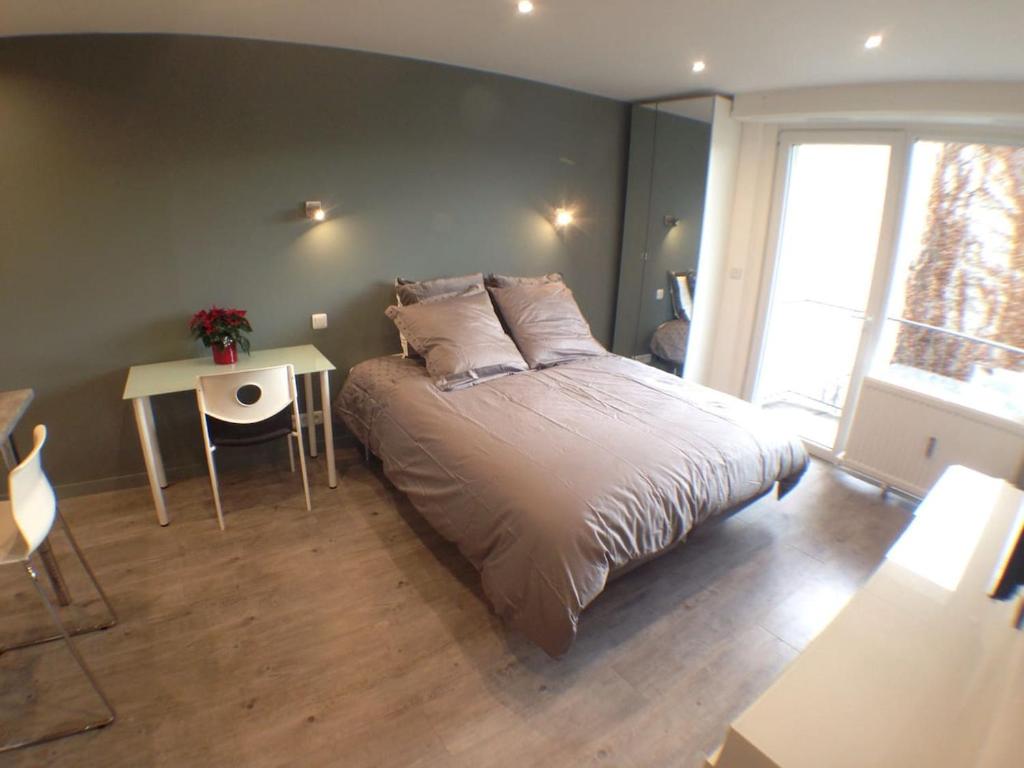 une chambre avec un grand lit et une table dans l'établissement Studio flambant neuf, calme & balcon, à Strasbourg