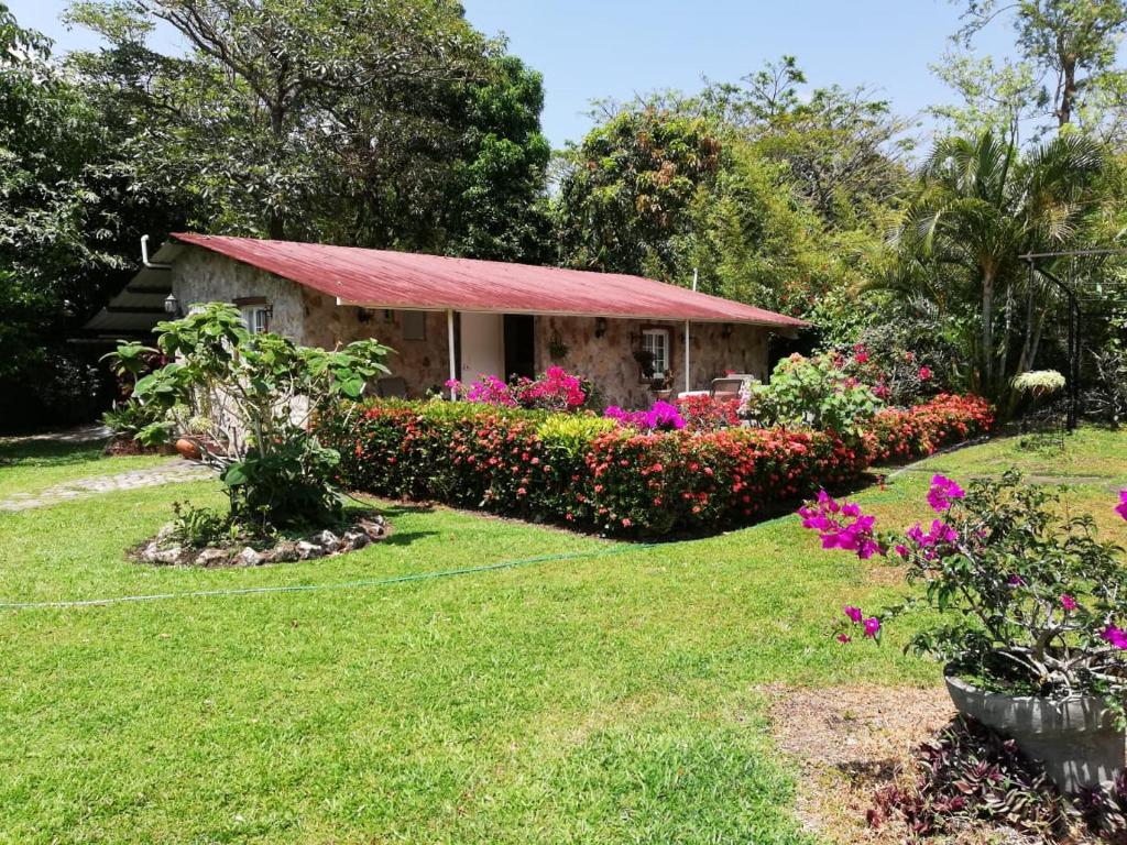 ogród z małym domkiem z kwiatami w obiekcie Valle Paradise w mieście Valle de Anton