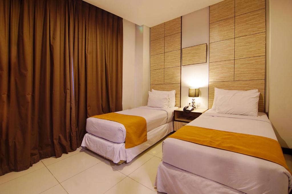 Postel nebo postele na pokoji v ubytování Royal Hotel Bogor