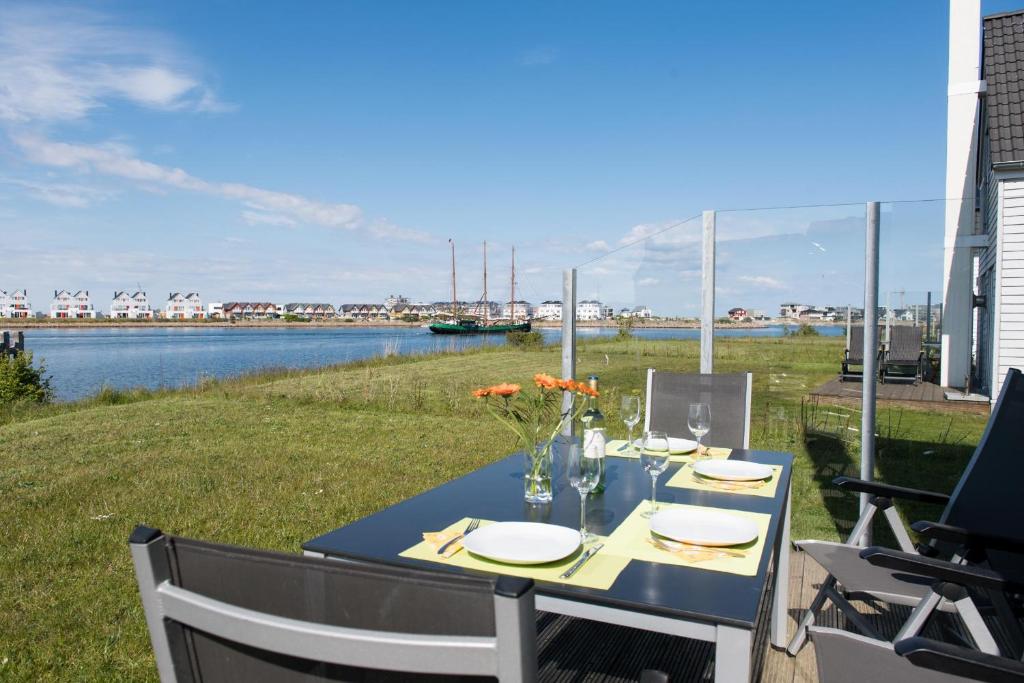 a table with plates and flowers on top of a patio at Sunshine in Olpenitz