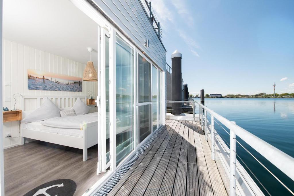 a balcony with a bed and a view of the water at Kleine Insel in Olpenitz
