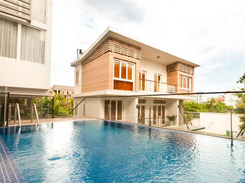 ein Haus mit einem Pool vor einem Gebäude in der Unterkunft Glenwood City Resort in Ho-Chi-Minh-Stadt