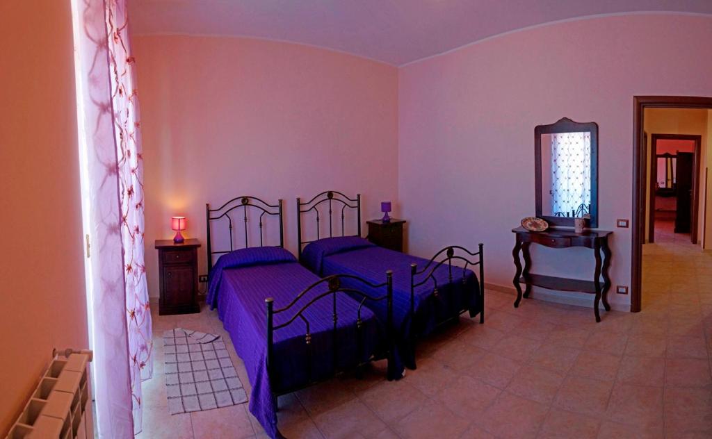 1 Schlafzimmer mit 2 Betten, einem Tisch und einem Spiegel in der Unterkunft La Casa Di Mirò in Catanzaro Lido