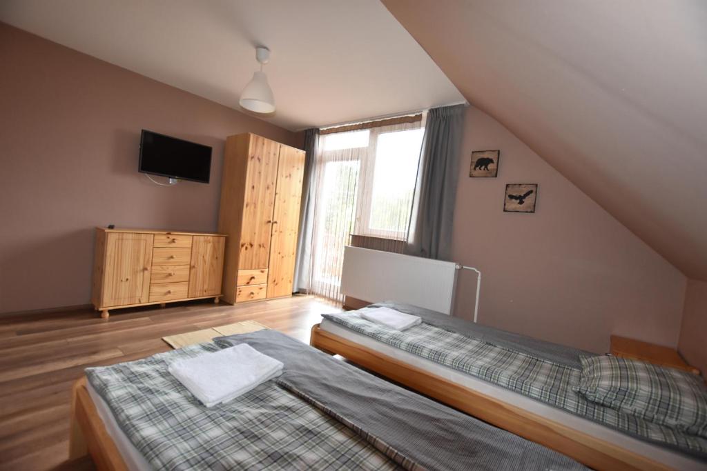 sypialnia na poddaszu z 2 łóżkami i telewizorem w obiekcie Borsi Apartman w mieście Balatonalmádi