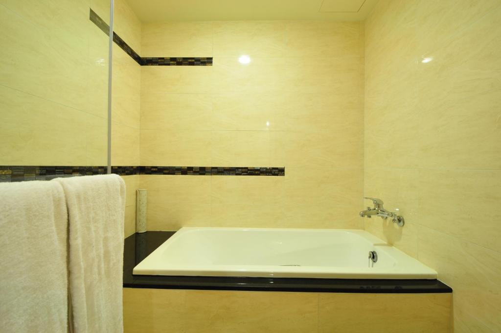 a bathroom with a white sink and a shower at Goodness Plaza Hotel in Taishan