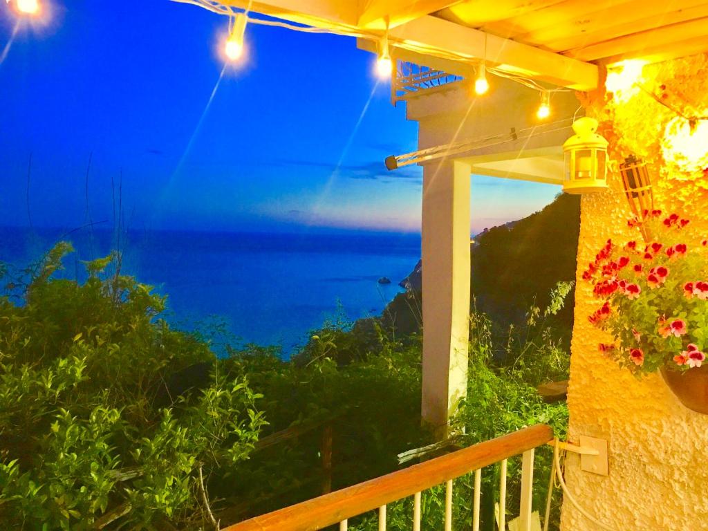 a balcony with a view of the ocean at night at La Finestra sul fiordo in Furore
