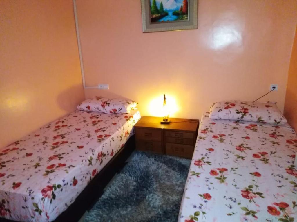 1 dormitorio con 2 camas y mesa con lámpara en Marrakech Family appartements en Marrakech