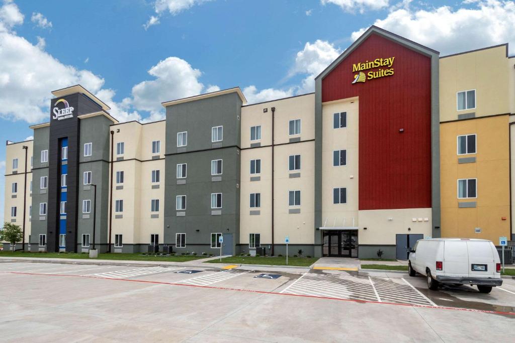 een groot gebouw met een busje geparkeerd op een parkeerplaats bij Sleep Inn & Suites Bricktown - near Medical Center in Oklahoma City