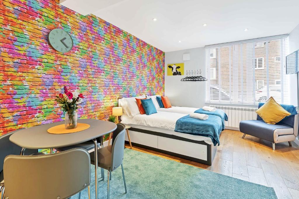 - une chambre dotée d'un mur coloré avec un lit et une table dans l'établissement Rainbow Studio - By My Getaways, à Brighton et Hove