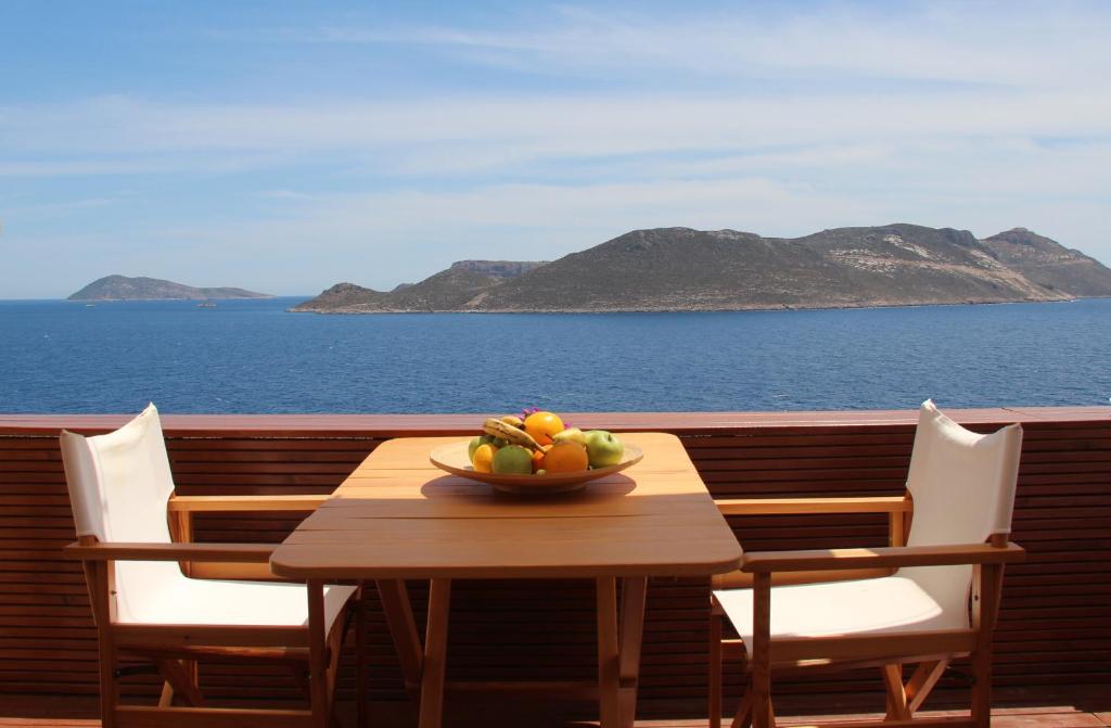 a bowl of fruit on a wooden table on a balcony at Lycia Hotel in Kaş