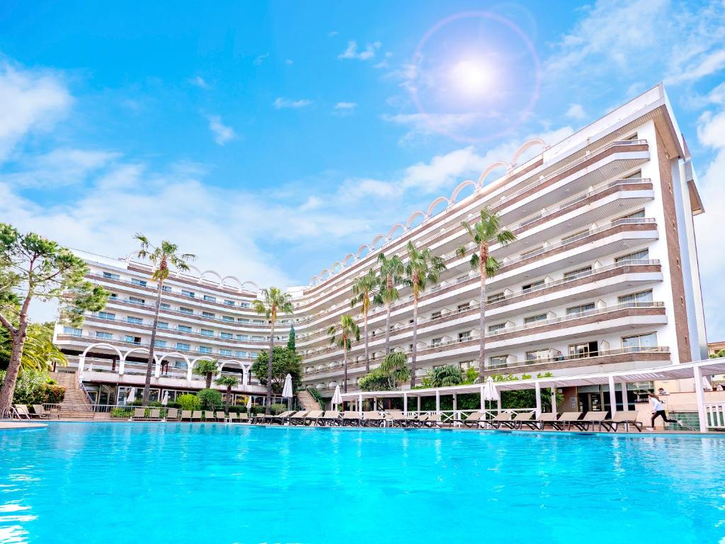 un gran hotel con una gran piscina frente a él en Golden Port Salou & Spa en Salou