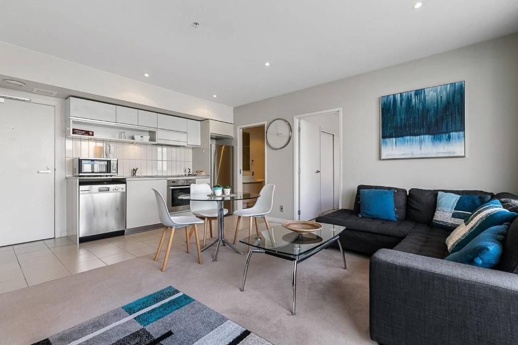- un salon avec un canapé et une table dans l'établissement Two Bedroom Apartment - Pool, Gym & Free Parking!, à Auckland