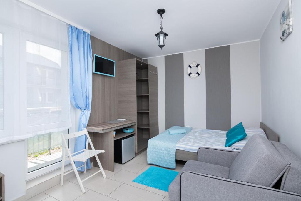 a small bedroom with a bed and a desk at Villa Baltic Karwia in Karwia