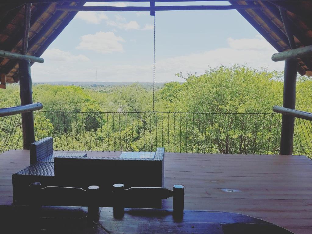 a screened in porch with a couch and a view at Bush and Gables House in Marloth Park