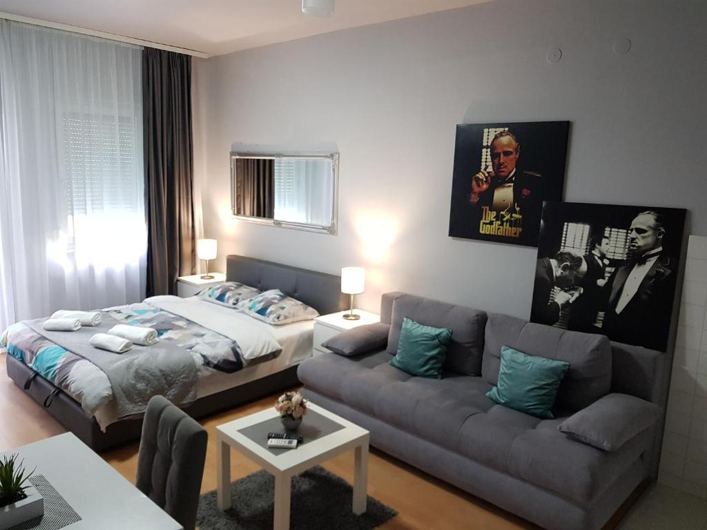 un soggiorno con divano e letto di Godfather Luxory Living Apartment a Niš