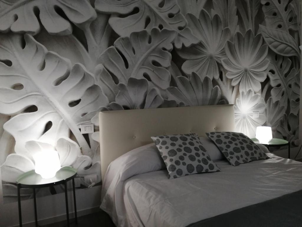 ein Schlafzimmer mit einem Bett und zwei Tischen mit Lampen in der Unterkunft B&B Casa Malù in Neapel