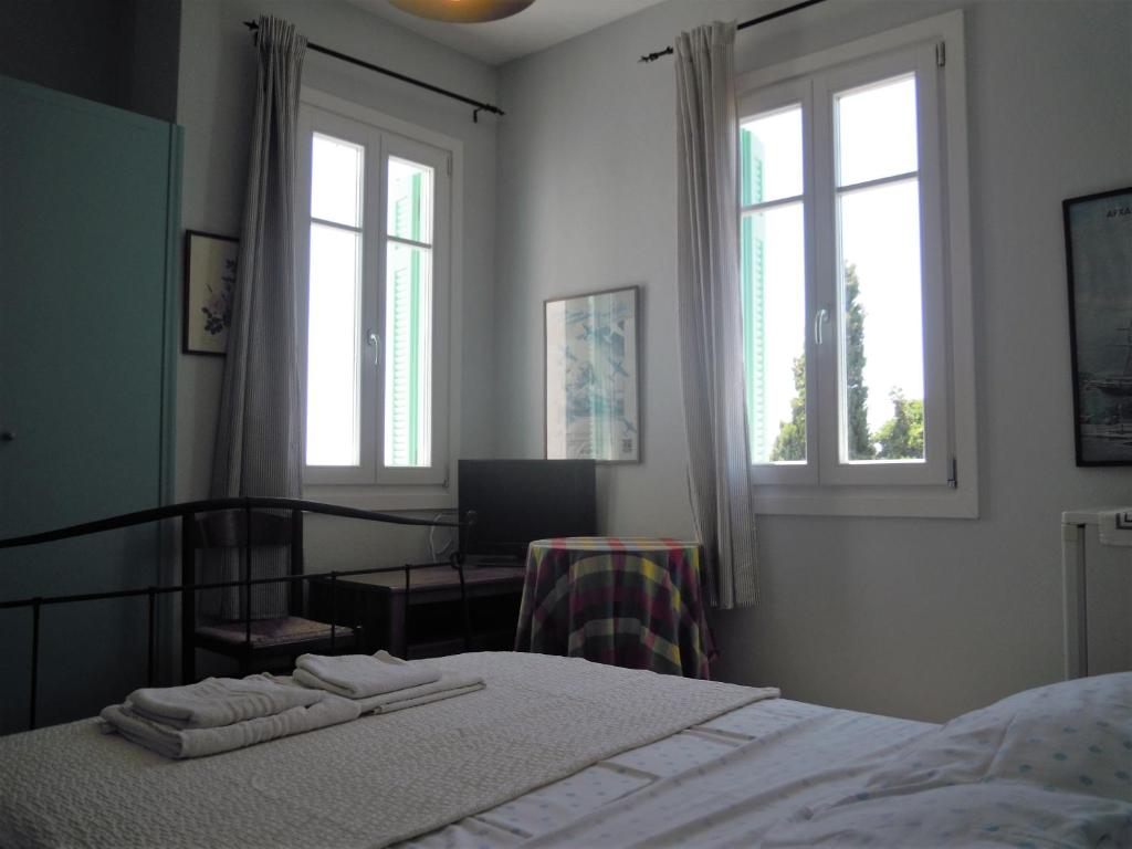 a bedroom with a bed and two windows at Blue Dolphin in Batsi