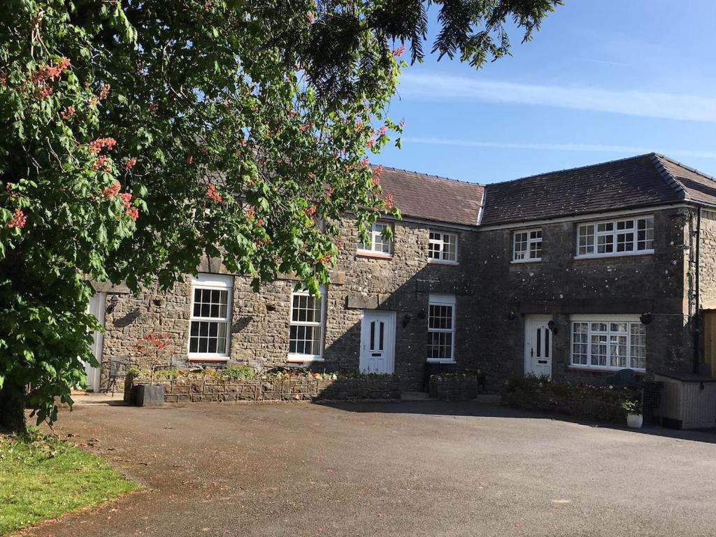 a brick house with white windows and a driveway at Mews Flat in Tenby