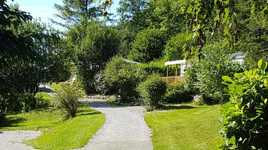 un camino de grava en un jardín con una casa en Camping Le Rey, en Louvie Juzon