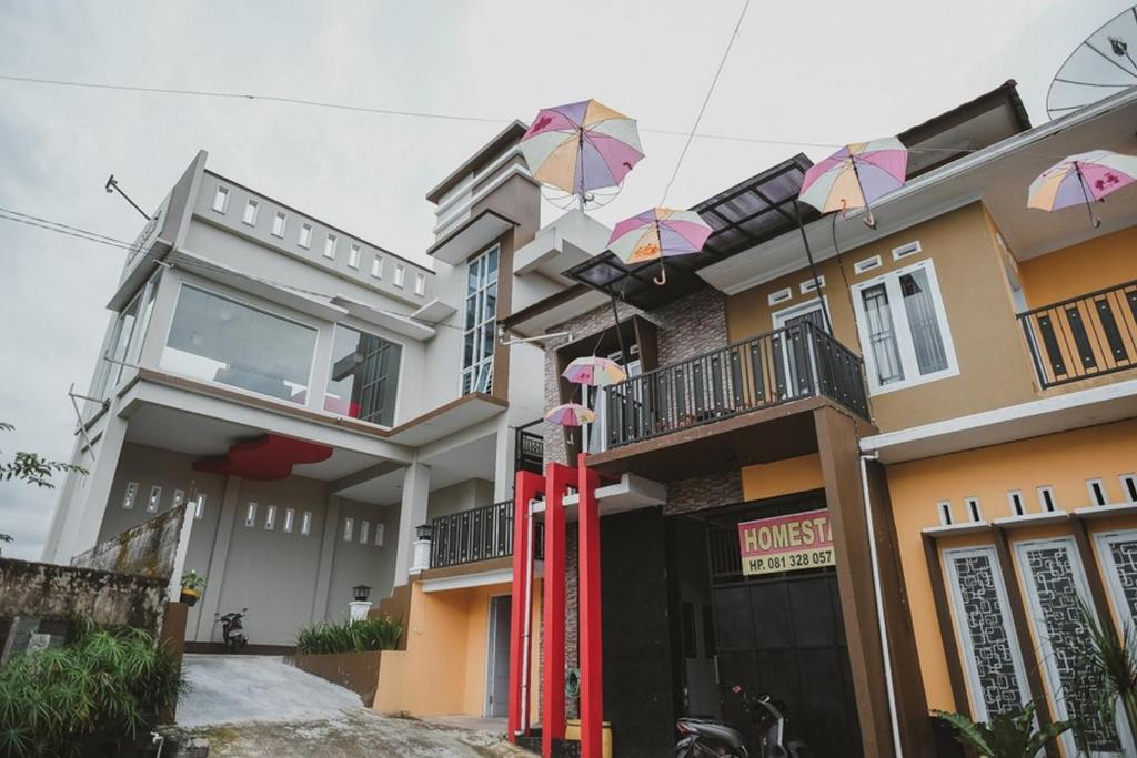 a building with umbrellas in front of it at RedDoorz Syariah @ Jalan Dieng in Wonosobo