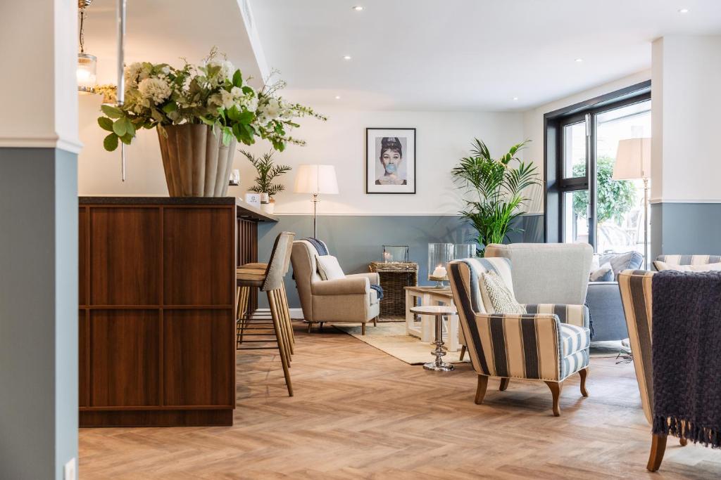 un soggiorno con sedie e tavolo con vaso di fiori di Hotel Cocoon a Ostenda