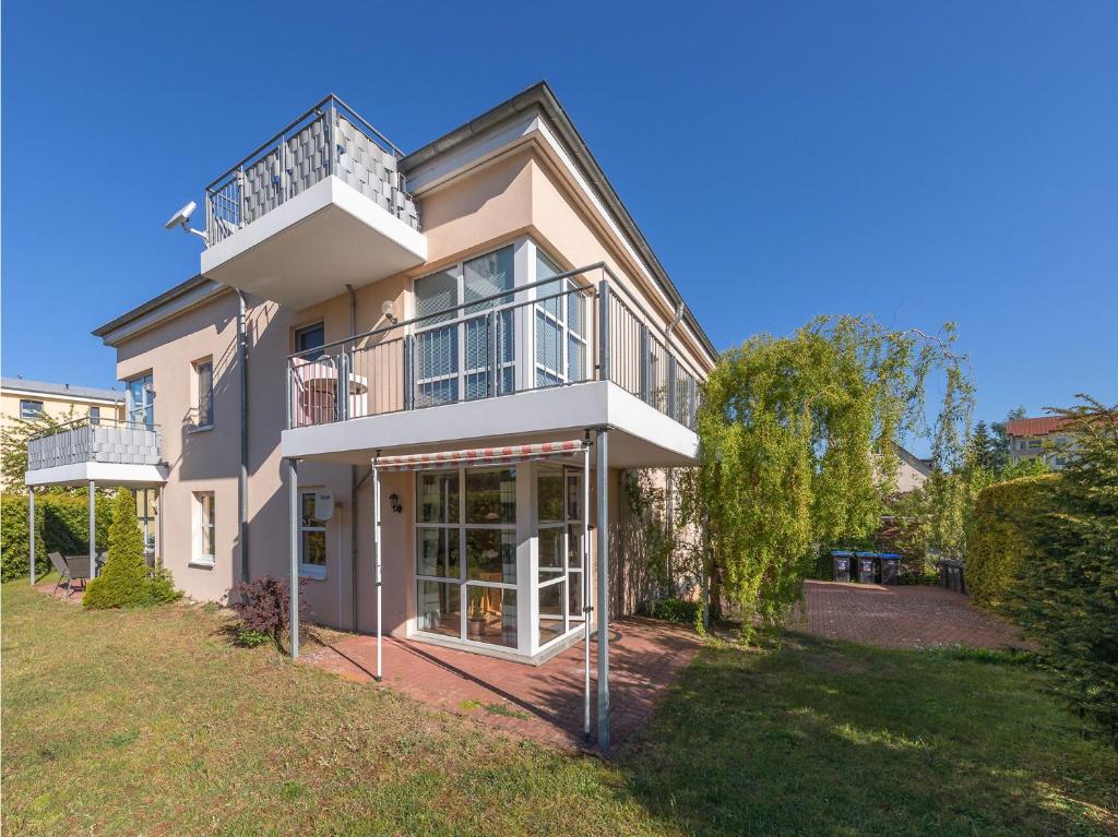 una grande casa con un balcone sopra di Apartmenthaus am Seeufer a Waren