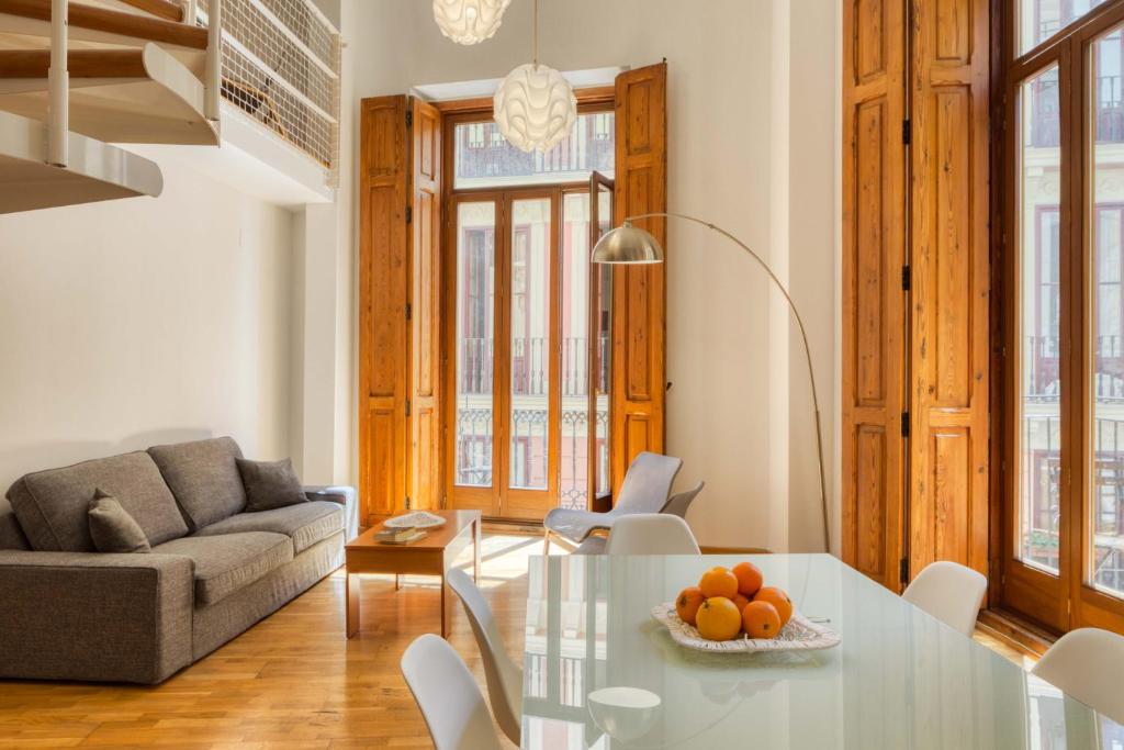 een woonkamer met een glazen tafel en een bank bij Palau de Palomar - PalomarGroup in Valencia