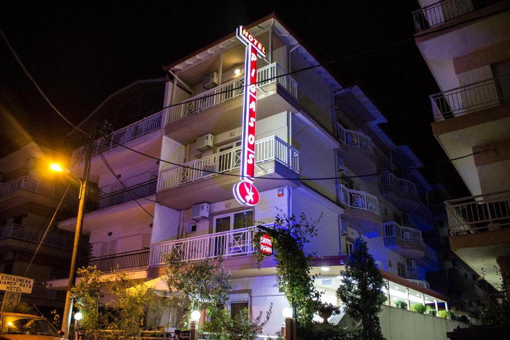 a tall building with a neon sign in front of it at Hotel Villa Pigasos in Paralia Katerinis