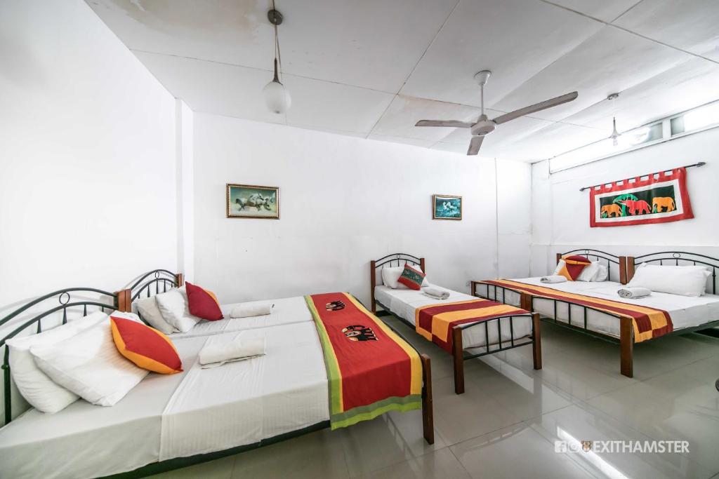 2 camas en una habitación con paredes blancas en Charlton Kandy City Rest en Kandy