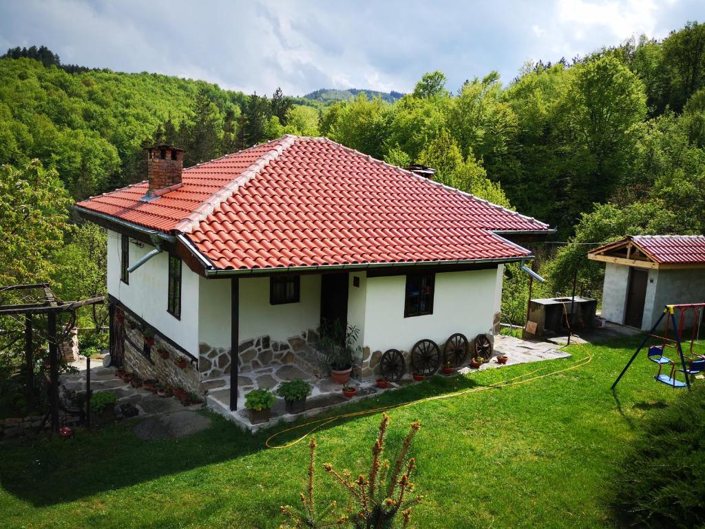 una pequeña casa blanca con techo rojo en Къща за гости Ножери en Tryavna