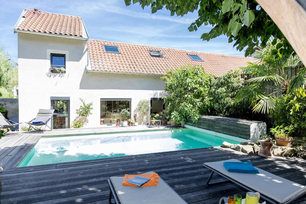 a villa with a swimming pool and a house at Une Odeur de Tilleul in Montbrison