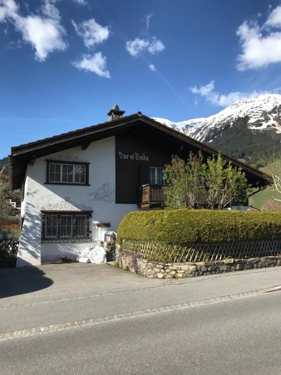 a white building with a mountain in the background at Studio in Klosters in Klosters