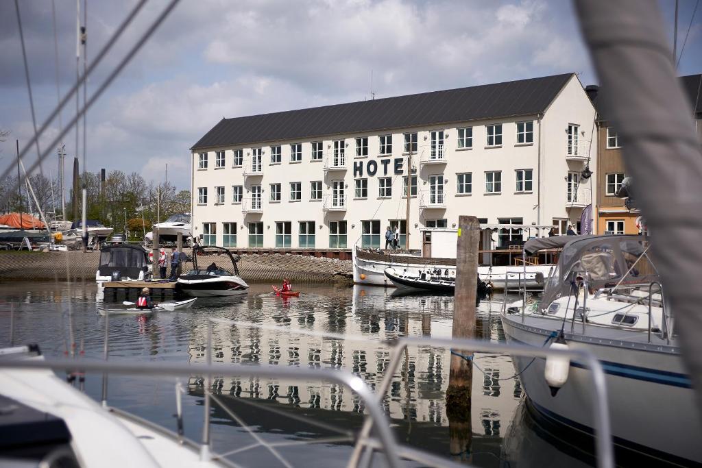 a hotel with boats in the water in front of a marina at BB-Hotel Aarhus Havnehotellet in Aarhus