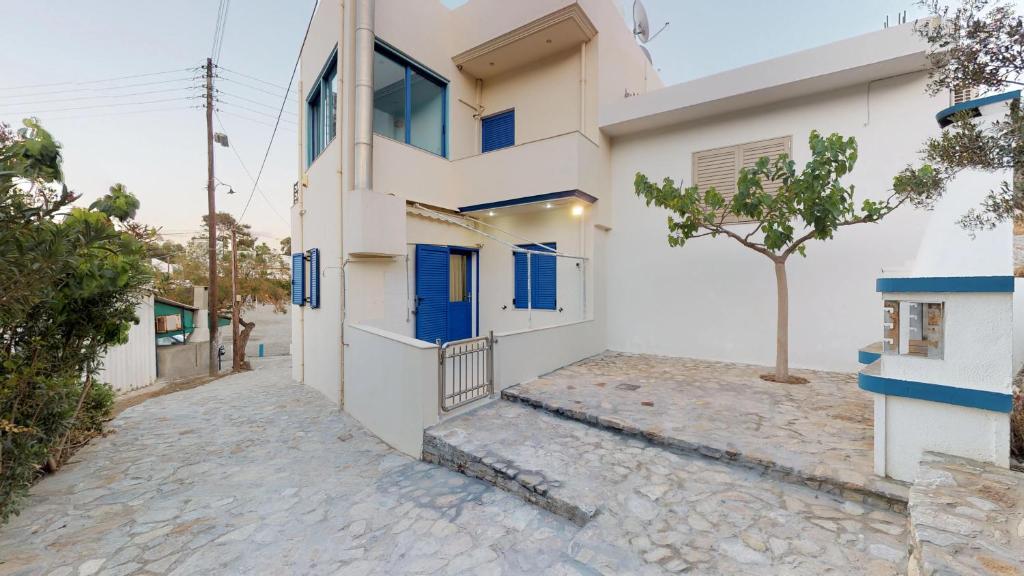 a house with blue doors on a street at Theaktis Homes in Kaloi Limenes